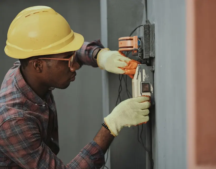 Contractor in a hard hat working on an electrical box