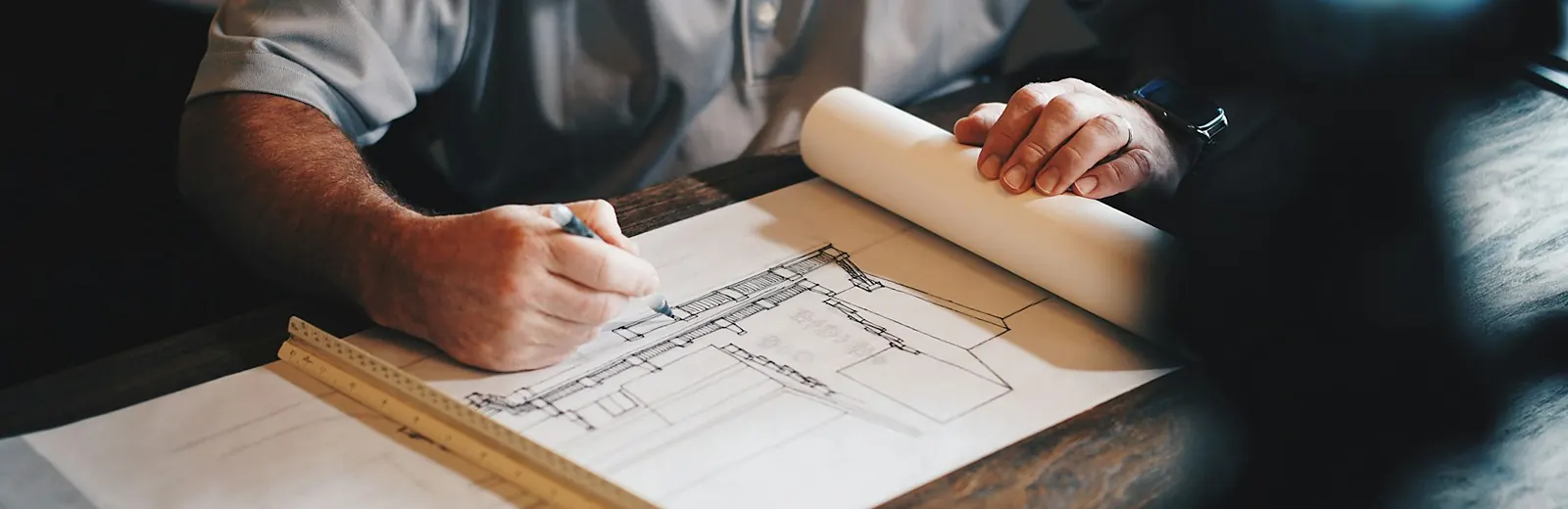 Contractor drawing up plans at a desk