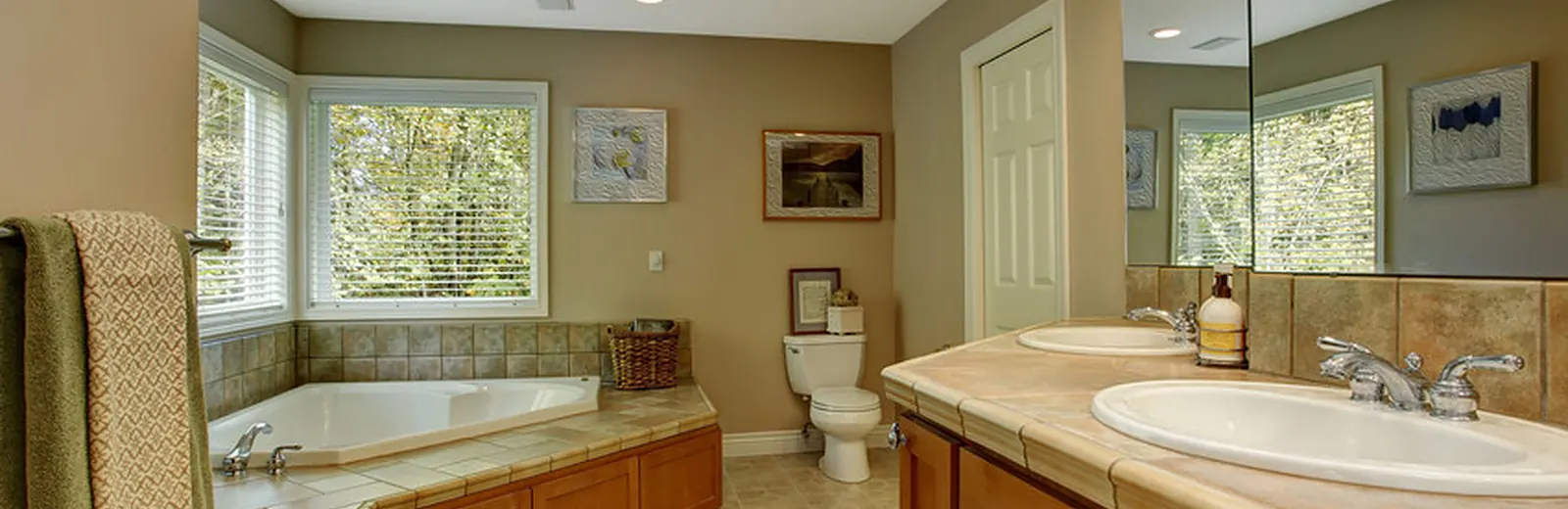 Bathroom with a corner soaking tub, oak vanity and skylight