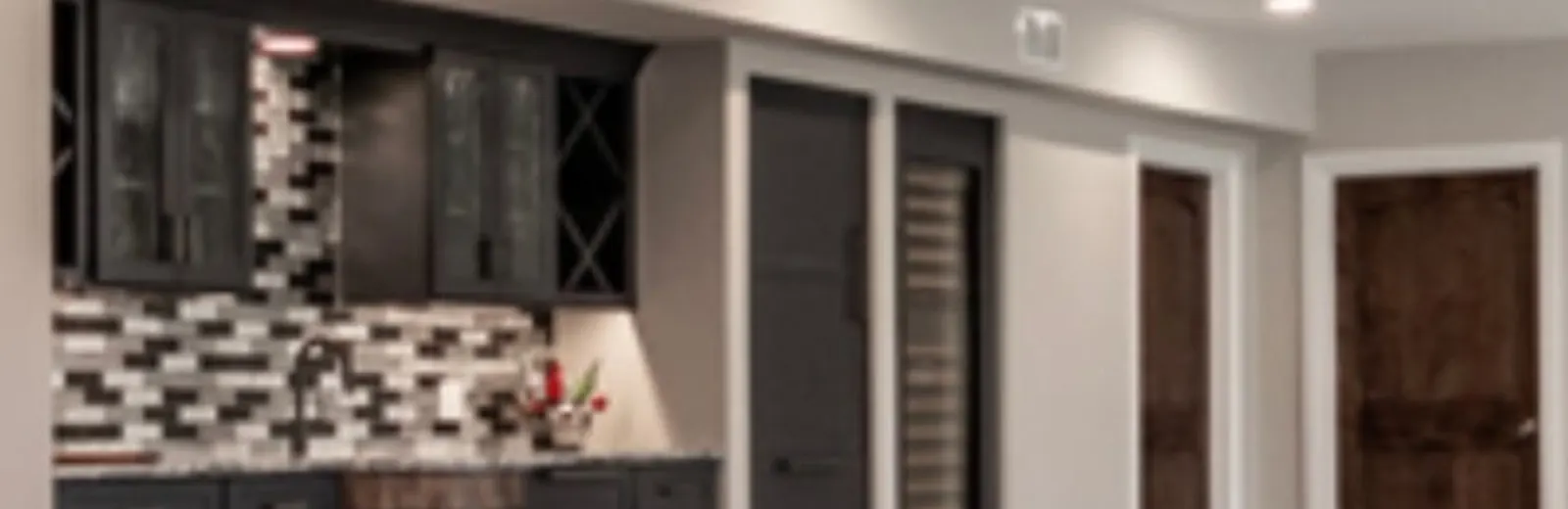 Finished basement with dark cabinetry and a tile backsplash