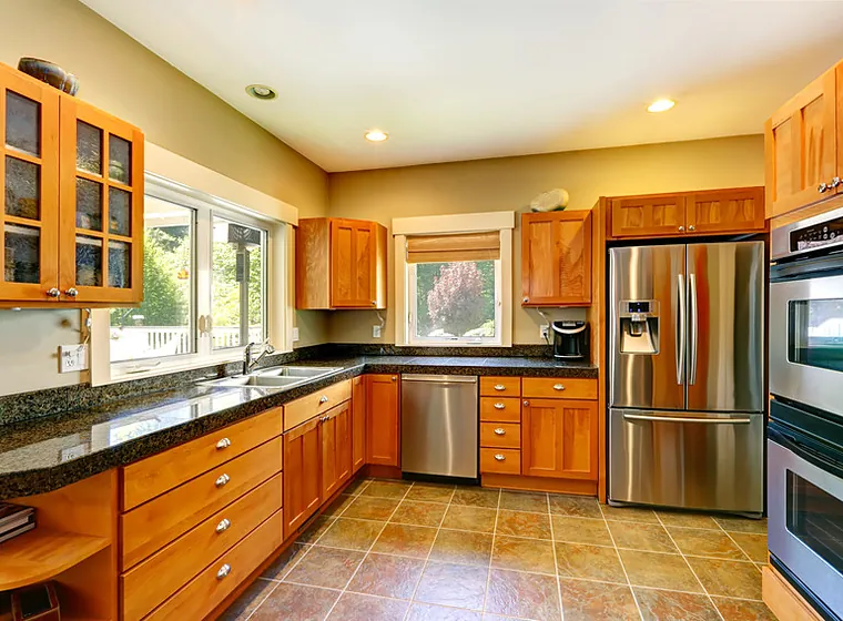 Kitchen with oak cabinets, black granite counters and stainless appliances