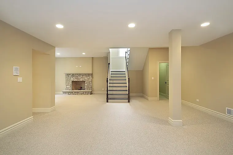 Finished basement with carpet, stone fireplace and a new staircase