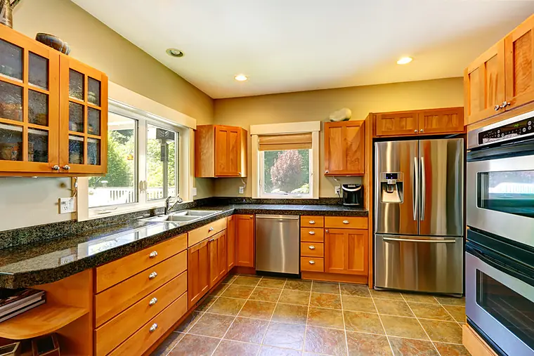 Kitchen with oak cabinets, black granite counters and stainless appliances