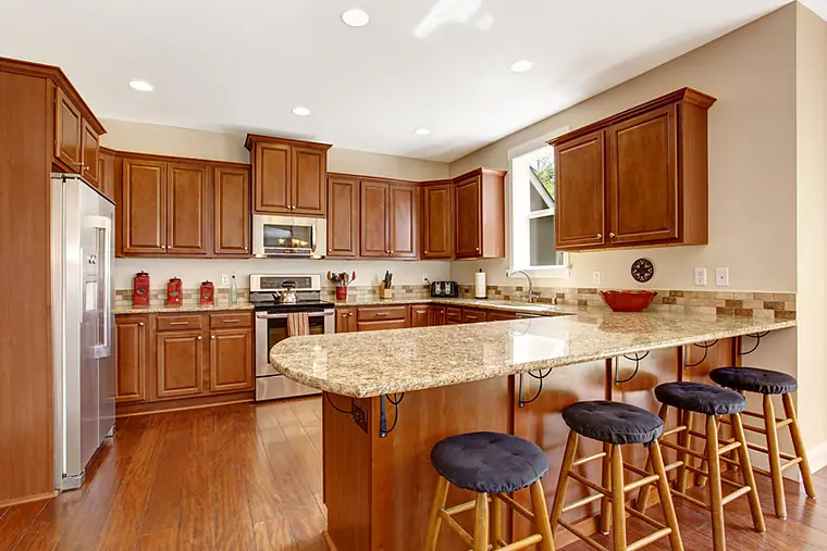 Remodeled kitchen with cherry cabinets, granite peninsula and bar stools