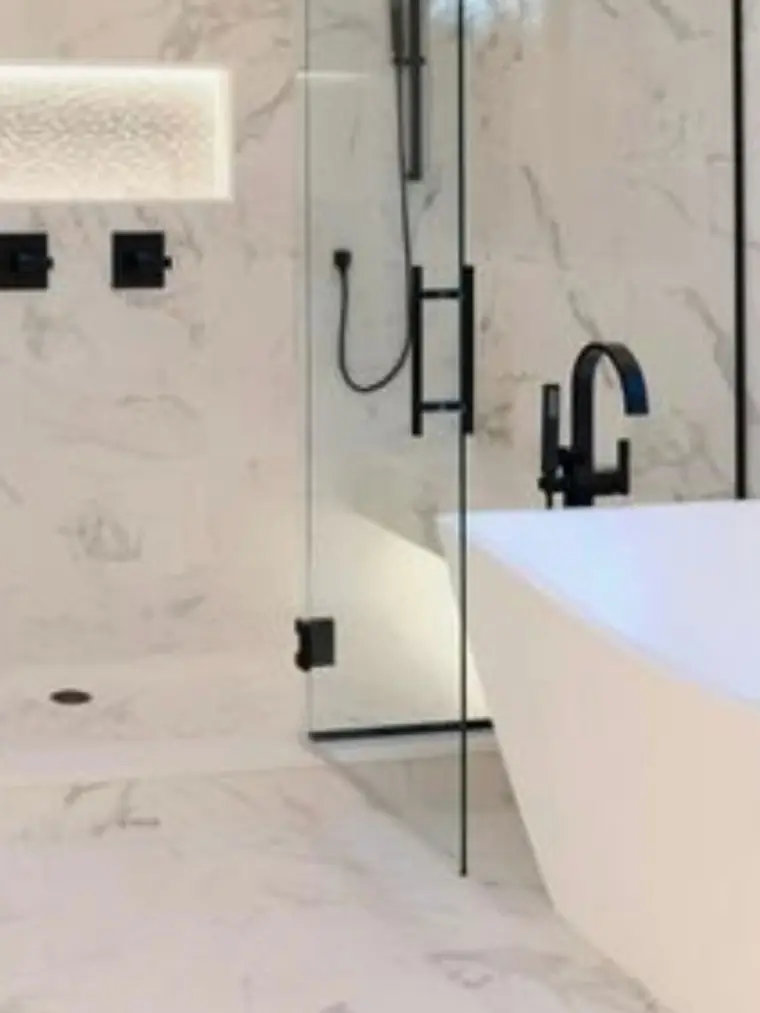 Marble bathroom with a freestanding tub and matte black fixtures