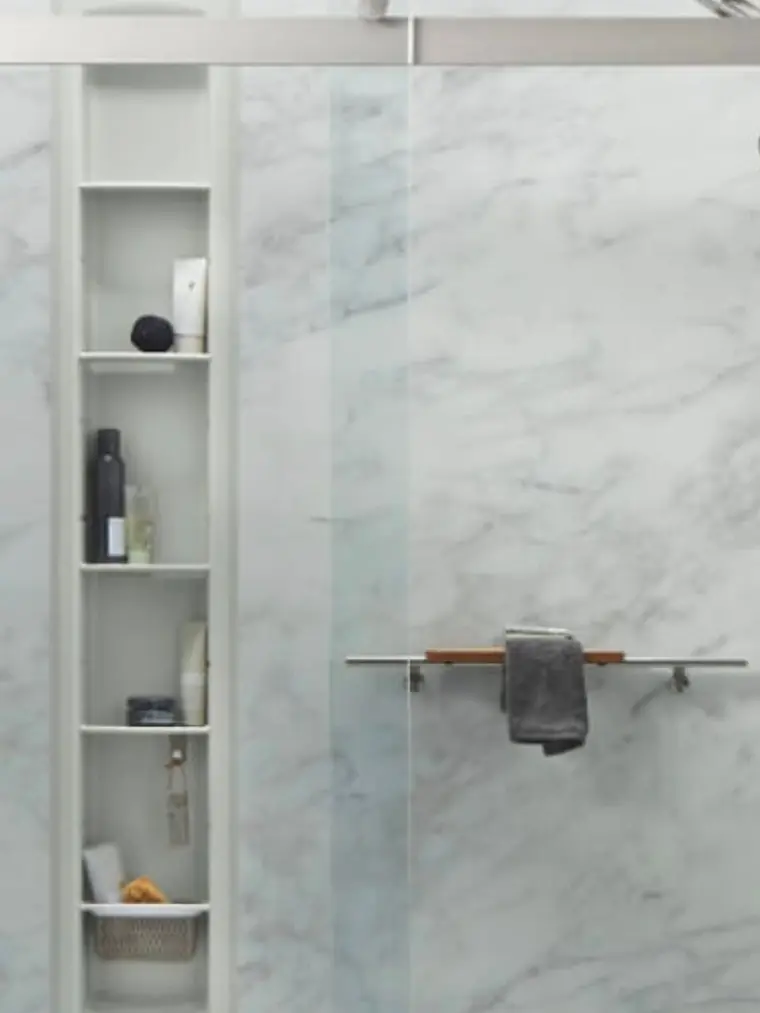 Marble shower with built-in shelving and a towel bar