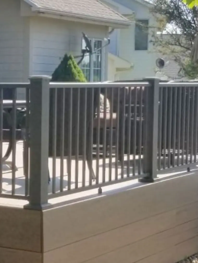 Gray aluminum deck railing on a covered porch