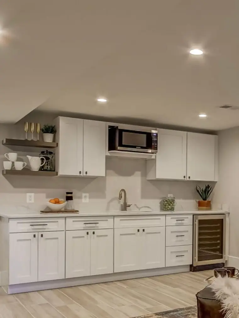 White kitchen with floating shelves, microwave nook and wine fridge