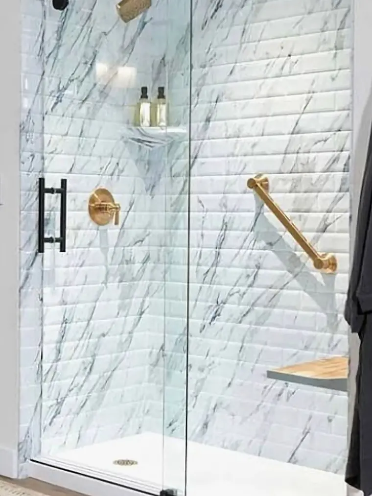 Marble shower with brushed gold fixtures and a corner shelf