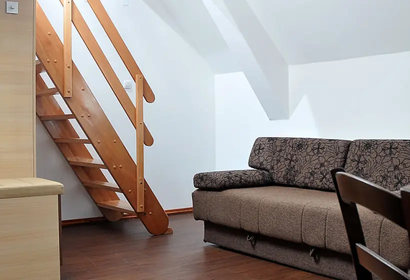 Attic conversion with sloped ceiling, wood stairs and a sofa